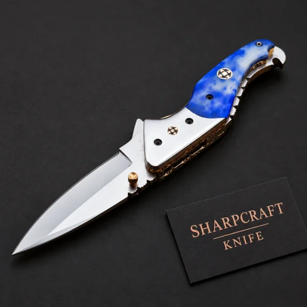 Blue Handle Folding Pocket Knife photographed on black with a Sharpcraft Knife visiting card