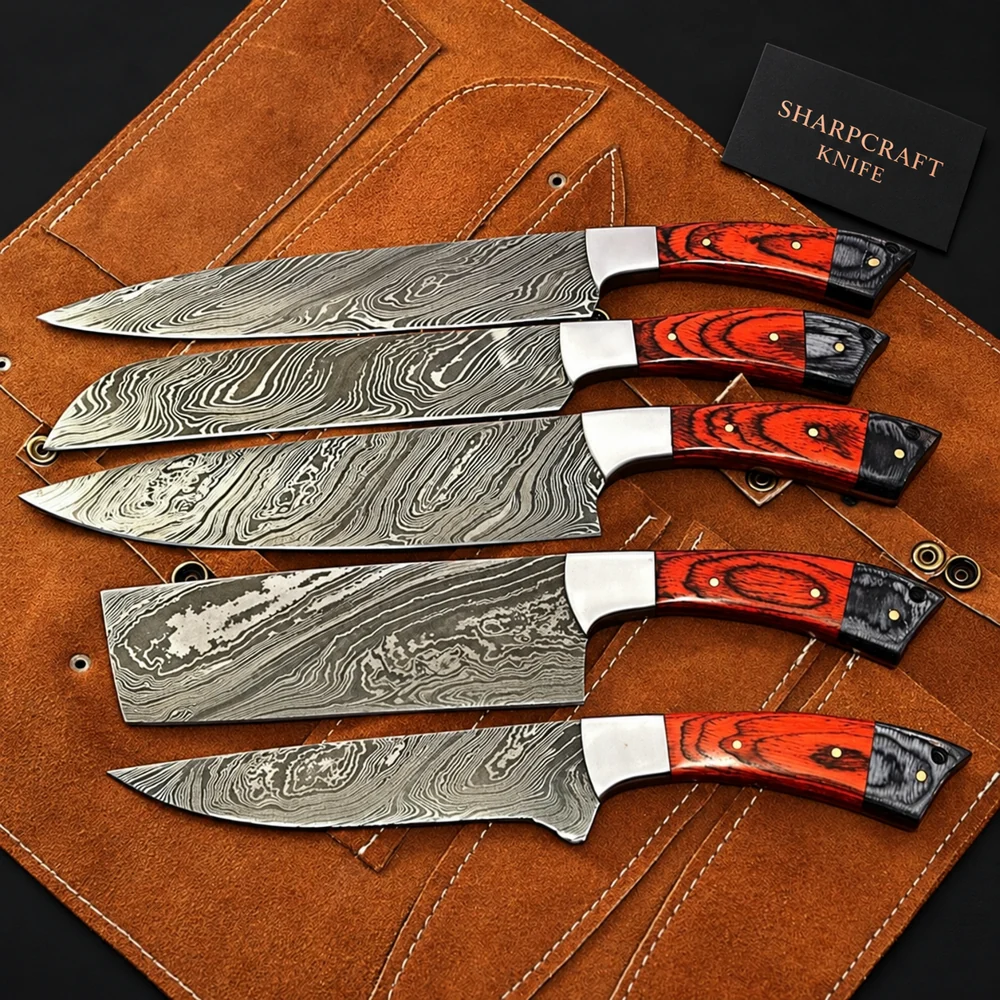 Five Damascus kitchen knives with red and black handles on a brown leather roll beside a Sharpcraft Knife card
